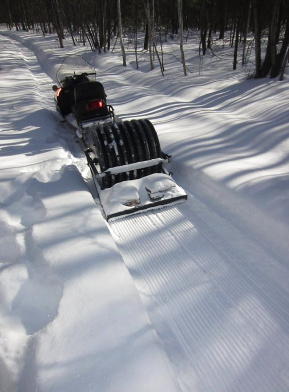 The snowmobile and the custom, 24" roller specifically built to groom fatbike trails.