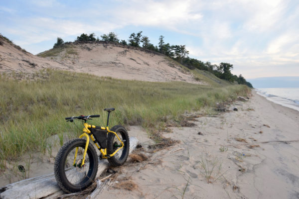 Test hill in the background while my bike leans against the part of th remains of the TS Christie which sank 83 years ago along this stretch of Lake Michigan