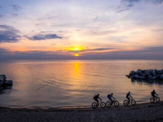 four people ride fat bikes at sunrise on Klode Beach in Whirefish Bay, WI